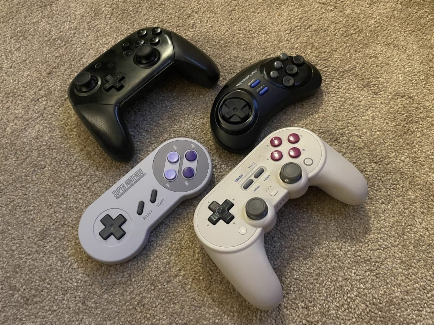 The retroflag classic 2. 4g controller-m alongside an 8bitdo pro 2, a switch pro controller, and an official snes switch controller.
