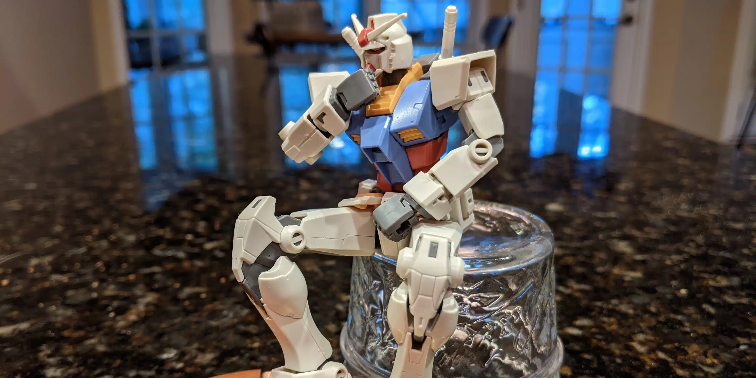A Gundam model is posed like the classic "The Thinker" sculpture.
