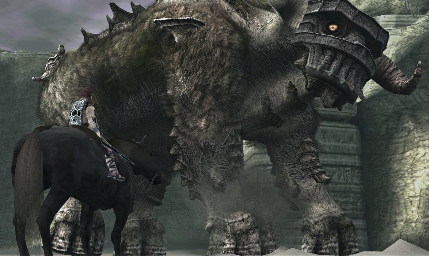 A screenshot from video game shadow of the colossus featuring the main character on a horse looking up at a multi-story-tall bull made of moss and ruined rock.